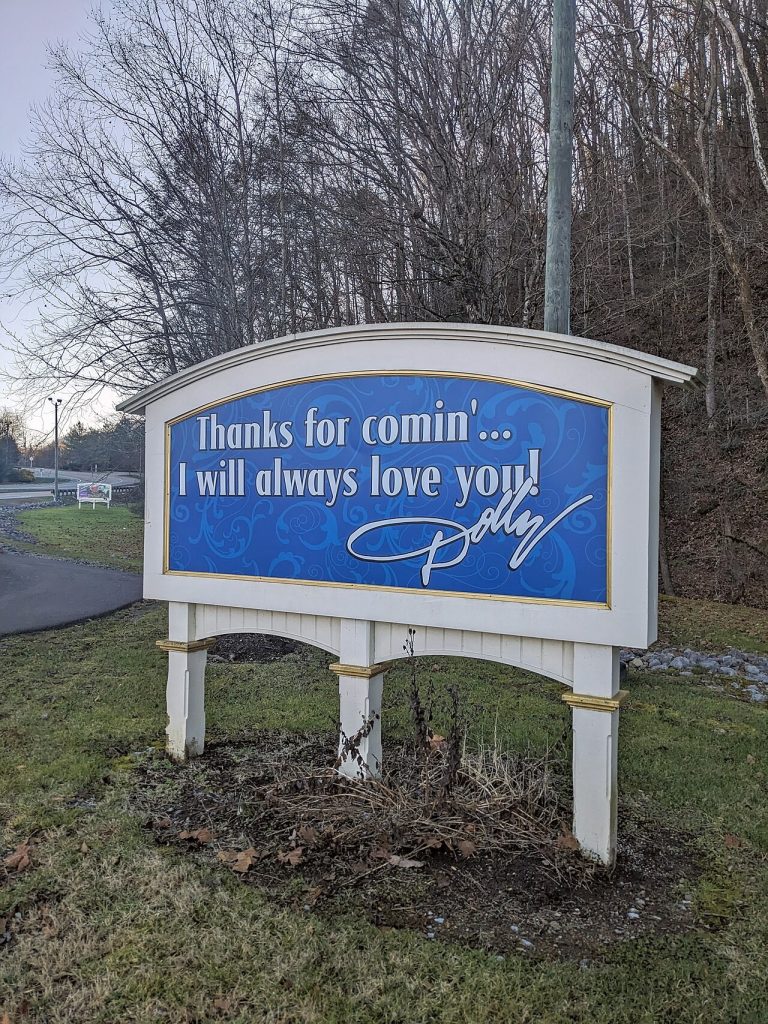 A Dollywood sign reading Thanks for comin' I will always love you with Dolly Parton's signature.