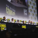 The cast and creators of HBO's Lanterns on stage at the San Diego Comic-Con 2026 panel, seated behind a Comic-Con backdrop.
