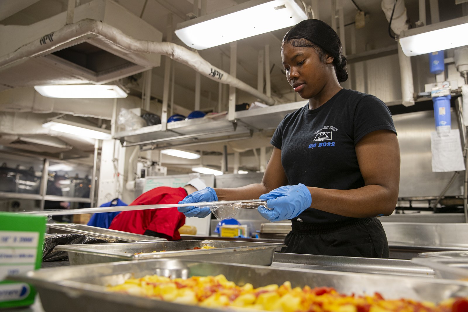 A Navy culinary specialist prepares food in a carrier galley aboard the USS George Washington, the carrier now heading in to relieve the Lincoln