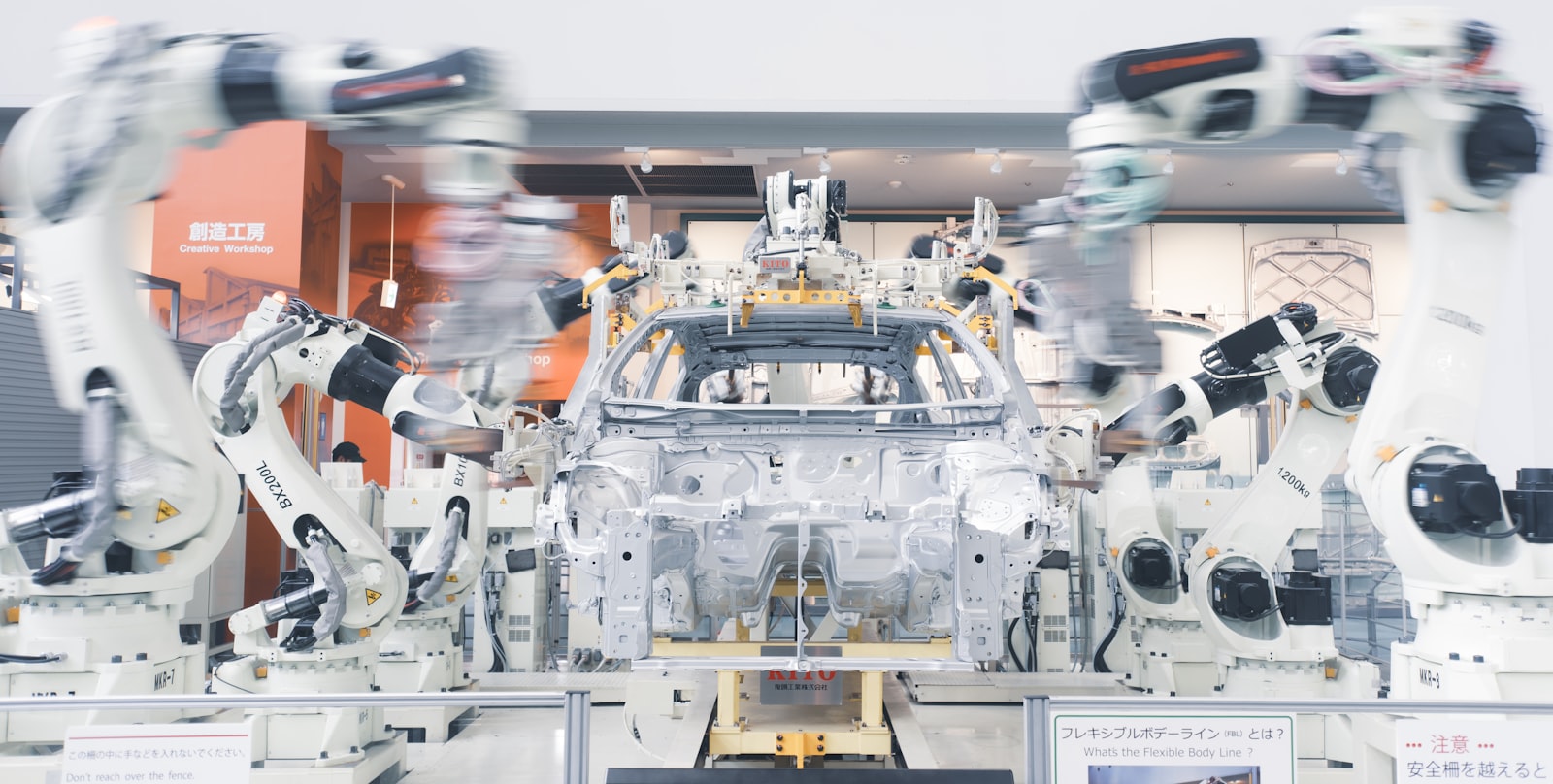 Robotic arms assembling a car body on an automotive factory line.