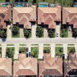 Aerial view of rows of single-family homes with tile roofs and pools in a Florida residential neighborhood