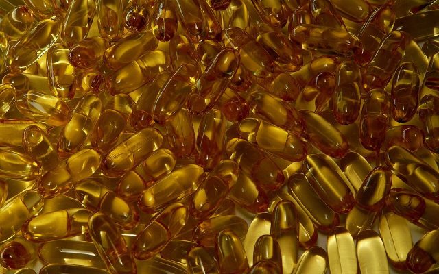A mass of golden supplement capsules