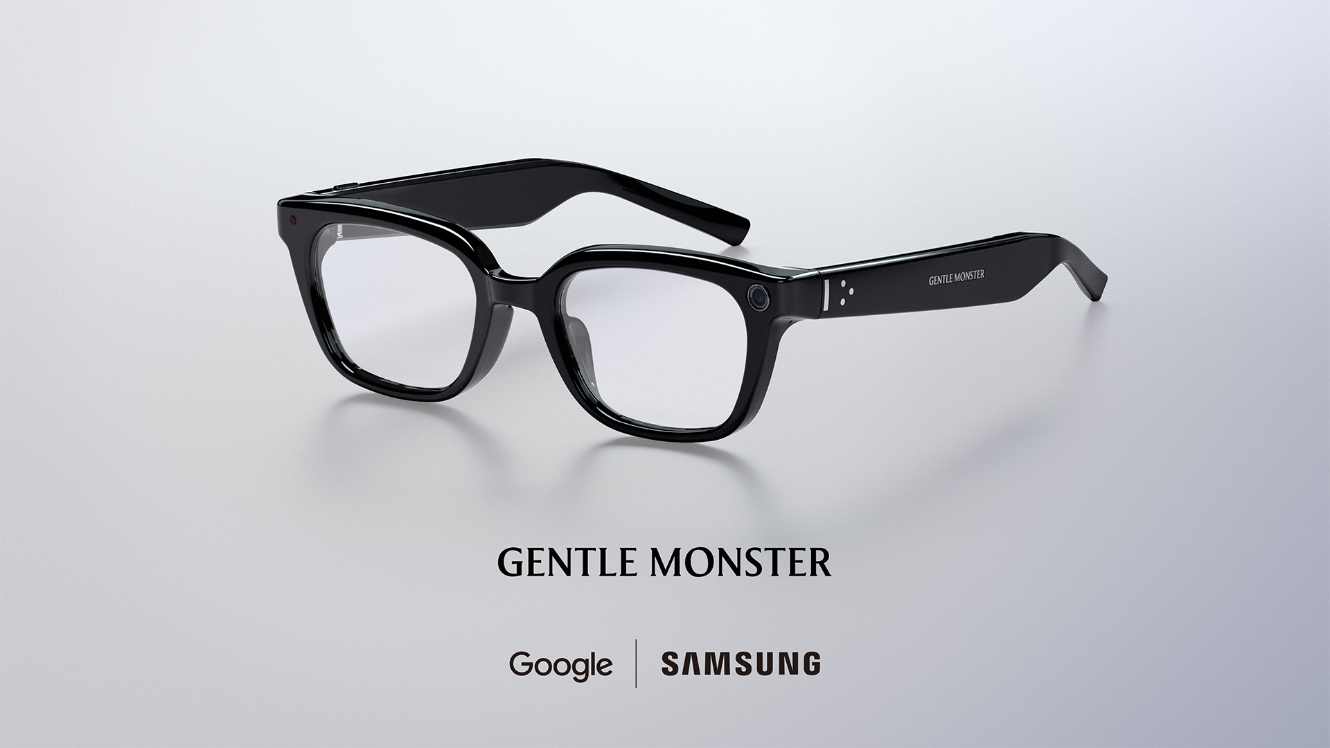 Black Gentle Monster smart-glasses frames shown at an angle, a small camera lens set into the left corner.
