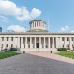 The Ohio Statehouse building in Columbus under a blue sky