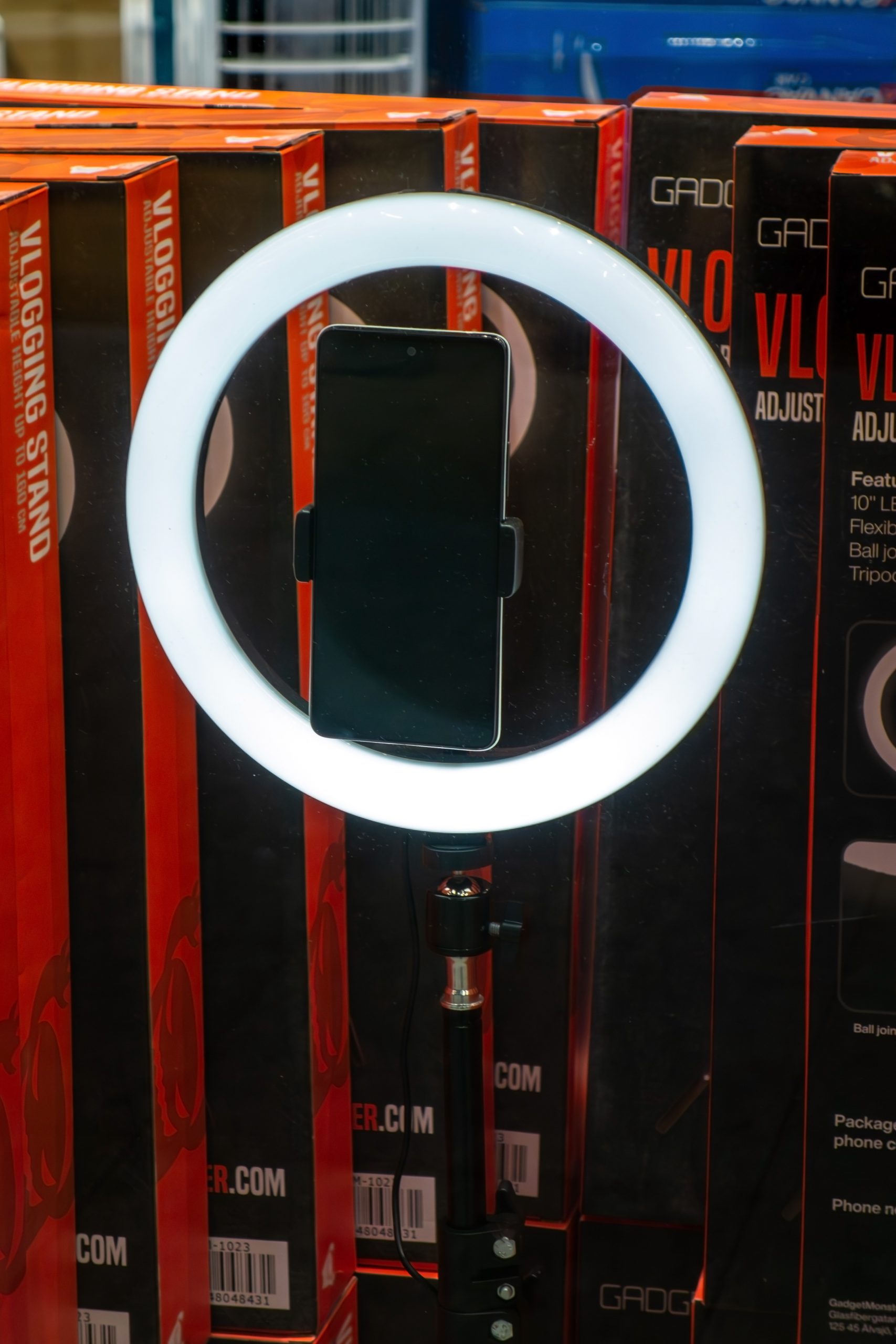 A ring light with a smartphone mounted on a tripod, the standard content-creator setup