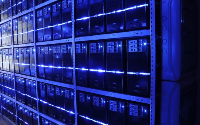 Rows of servers with blue and green status lights recede down a data center aisle.
