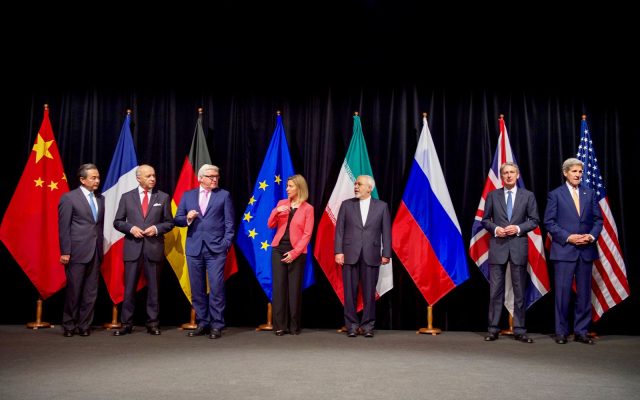 Seven foreign ministers stand in a row in front of national flags in Vienna after announcing the Iran nuclear deal