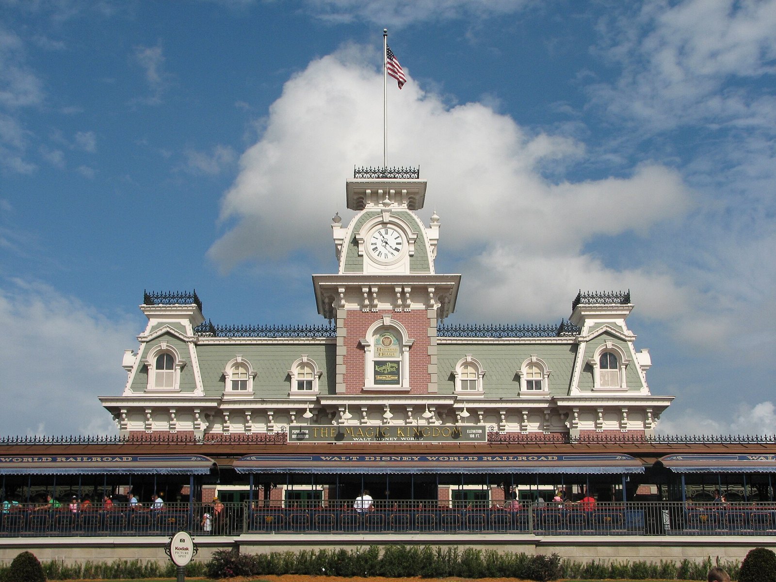The Main Street, U.S.A. railroad station at Magic Kingdom, a Victorian building with a clock tower and a Walt Disney World Railroad banner