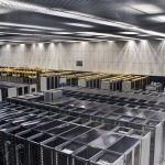 Rows of servers and cabling in a large research computing room.