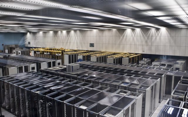 Rows of servers and cabling in a large research computing room.