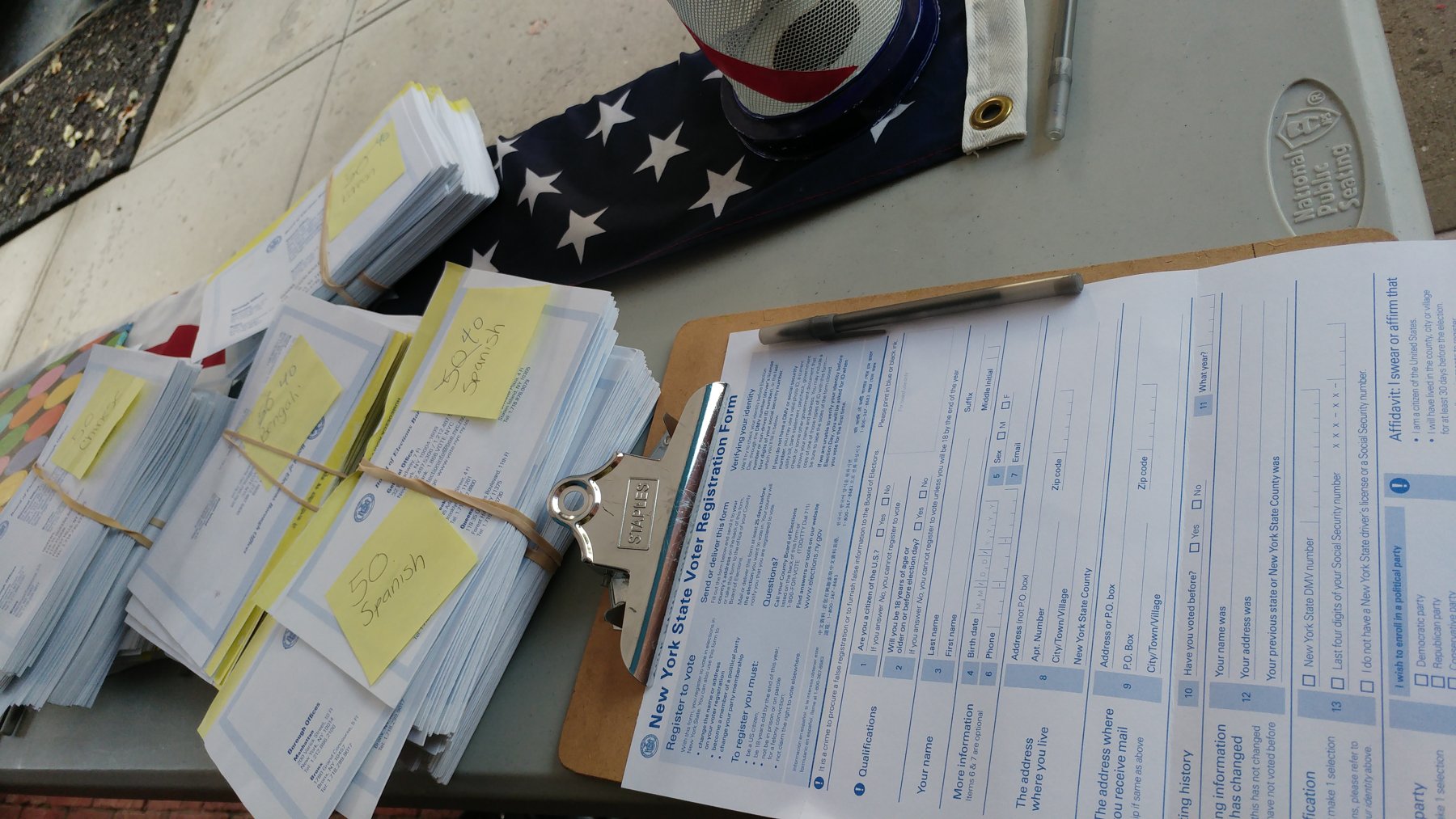 Blank voter registration application forms fanned out on a table.