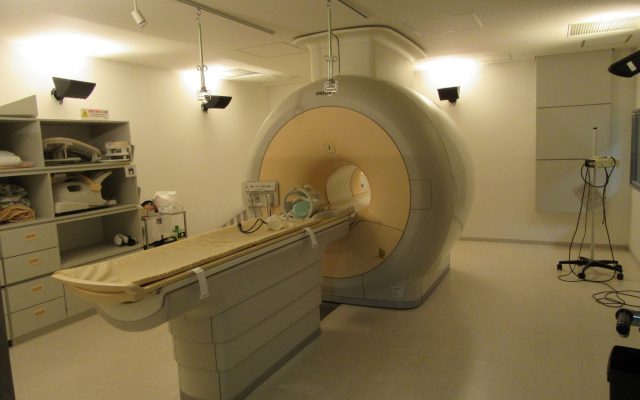 An MRI scanner with its patient table in a hospital imaging room