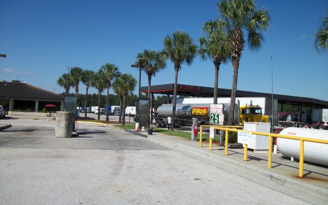 A Pilot Travel Centers tanker truck beside palm trees and a propane tank at a Flying J truck stop